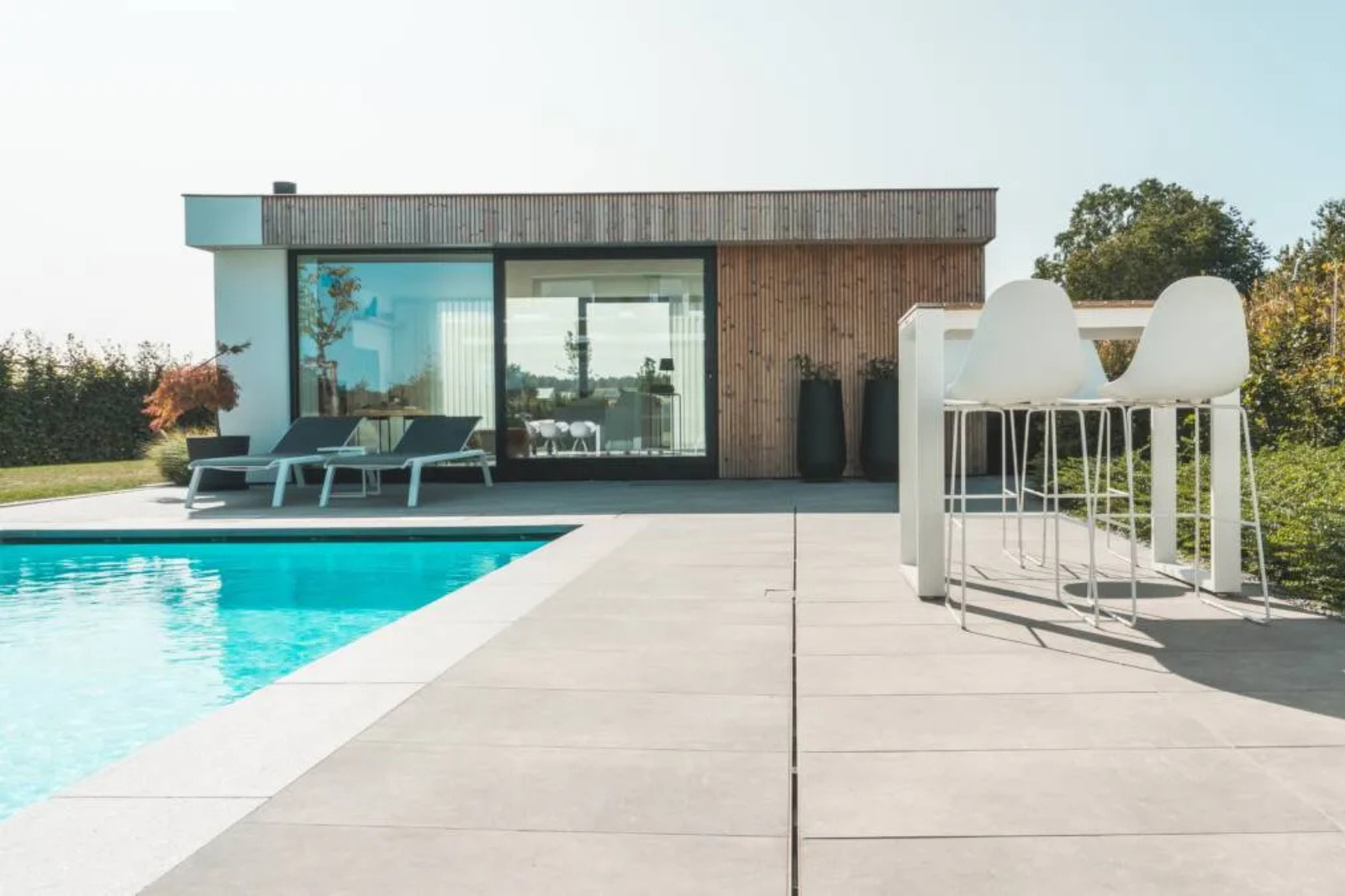 LPW inbouwzwembad in een moderne tuin met terras en poolhouse